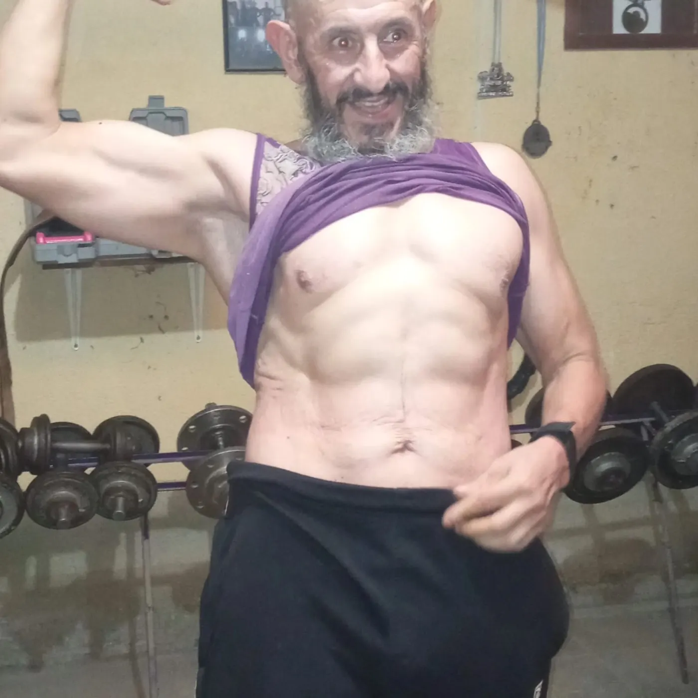 Fergym mostrando abdominales y bíceps en su gimnasio actual